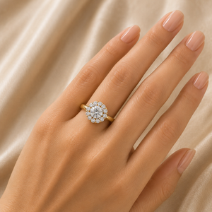 Elegant gold ring featuring a brilliant round center diamond surrounded by a halo of smaller diamonds, creating a classic floral-inspired sparkle.