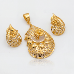 Elegant gold jewellery set featuring a floral filigree pendant and matching teardrop earrings with intricate openwork patterns, sculpted flowers, and polished gold detailing.