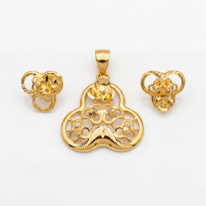 Intricately crafted gold jewellery set featuring a floral pendant and matching earrings with ornate openwork, curved motifs, and polished detailing.