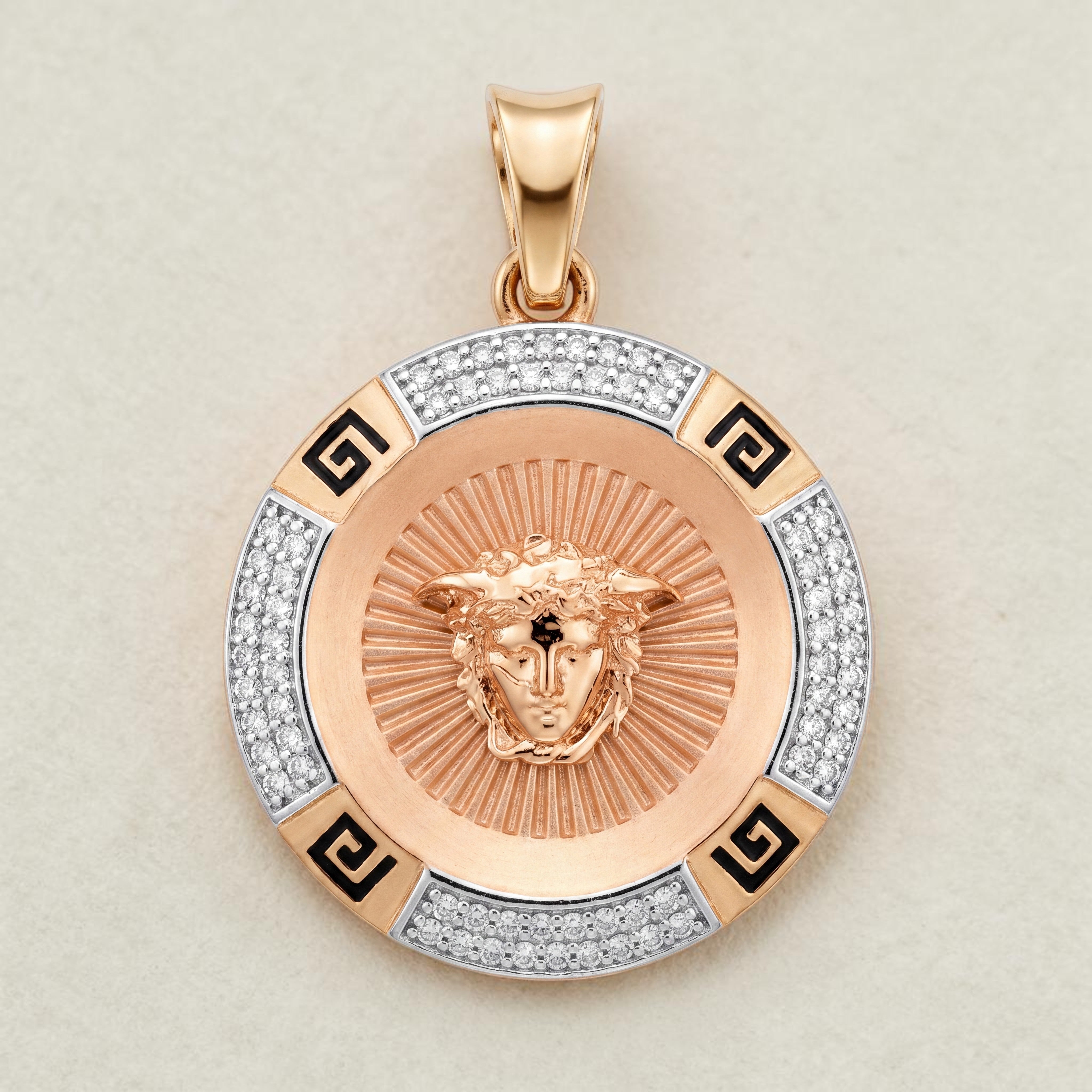 Round rose gold pendant featuring a detailed Medusa head motif at the center with radiant texture, surrounded by diamond-set segments and black enamel Greek key accents for a bold luxury design.