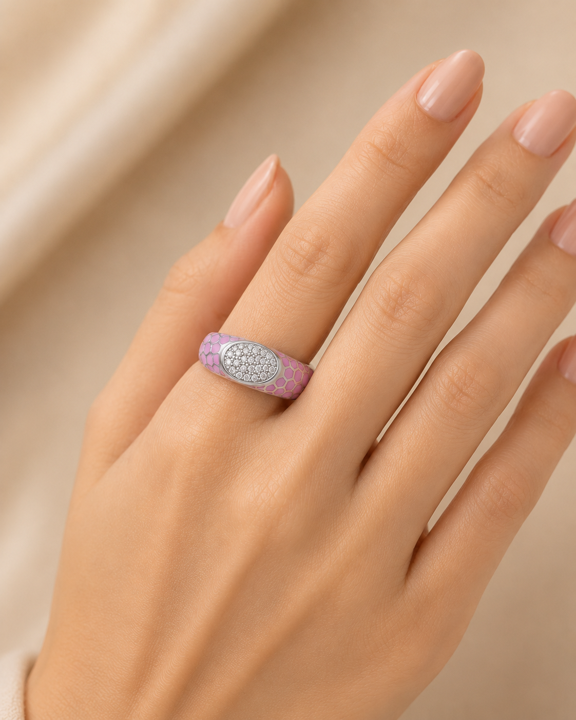Stylish gold ring featuring a soft pink enamel band with intricate floral detailing and a sparkling oval diamond cluster at the center.