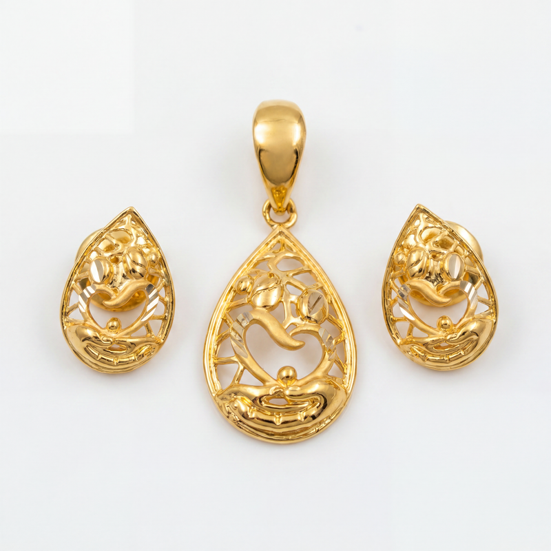 Elegant gold jewellery set featuring a teardrop-shaped pendant and matching earrings with intricate filigree work, floral accents, flowing motifs, and polished gold detailing.