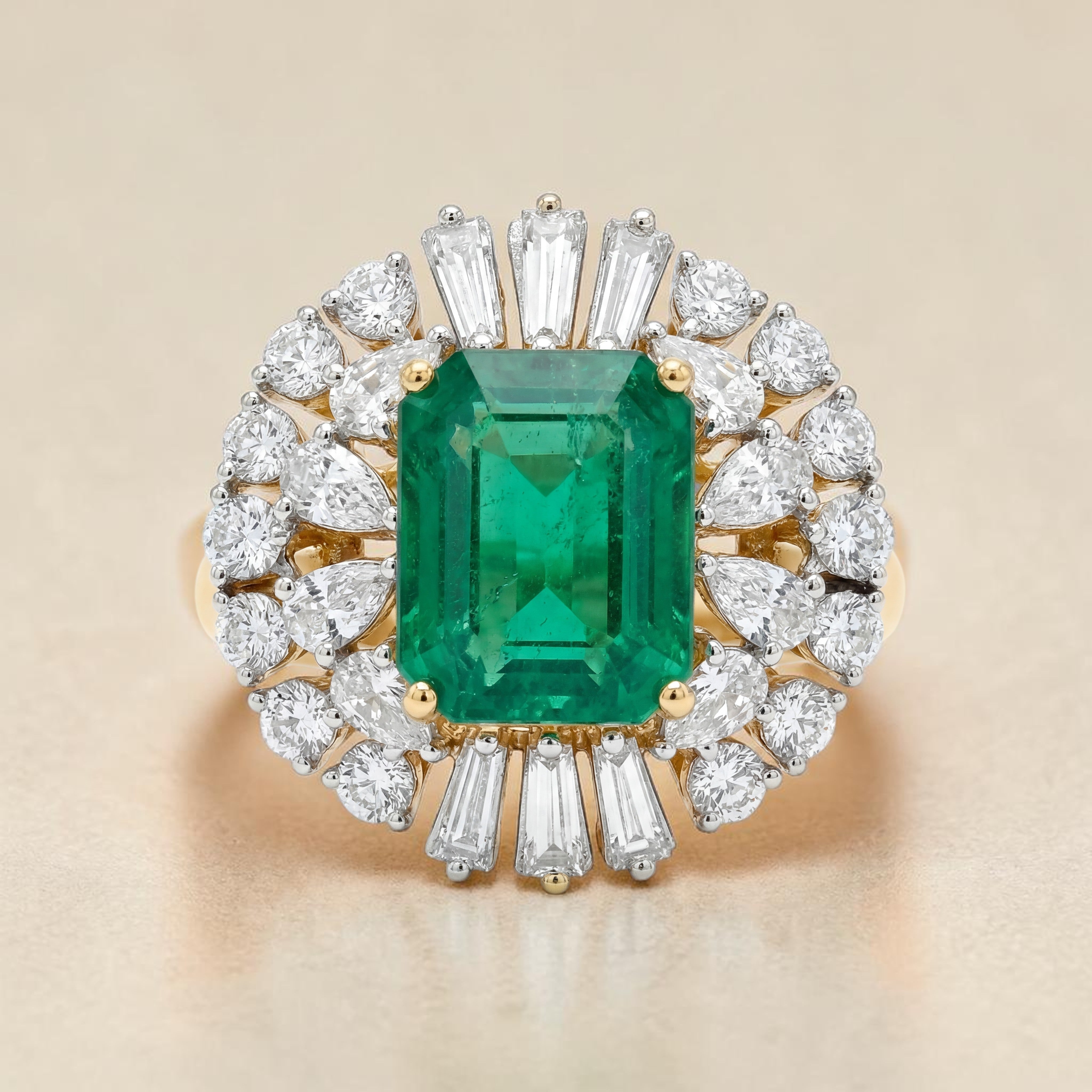 Yellow gold ring featuring a striking emerald-cut green gemstone center, surrounded by a radiant halo of pear-shaped and baguette diamonds arranged in a burst design for a bold and luxurious look.