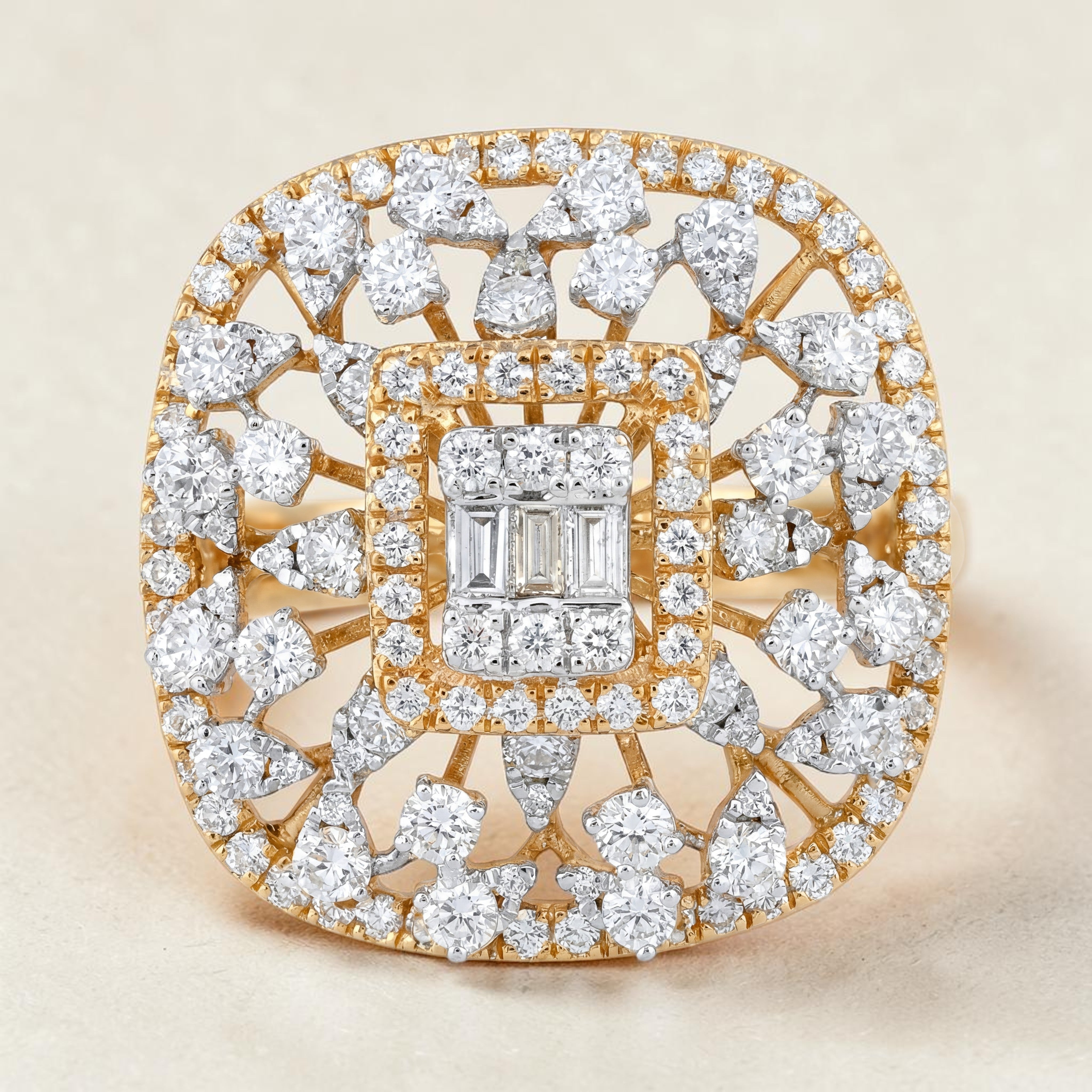 Luxurious square-shaped diamond cocktail ring in yellow gold featuring a baguette diamond cluster center, surrounded by a double halo and intricate openwork design with pear-shaped and round diamonds radiating outward.