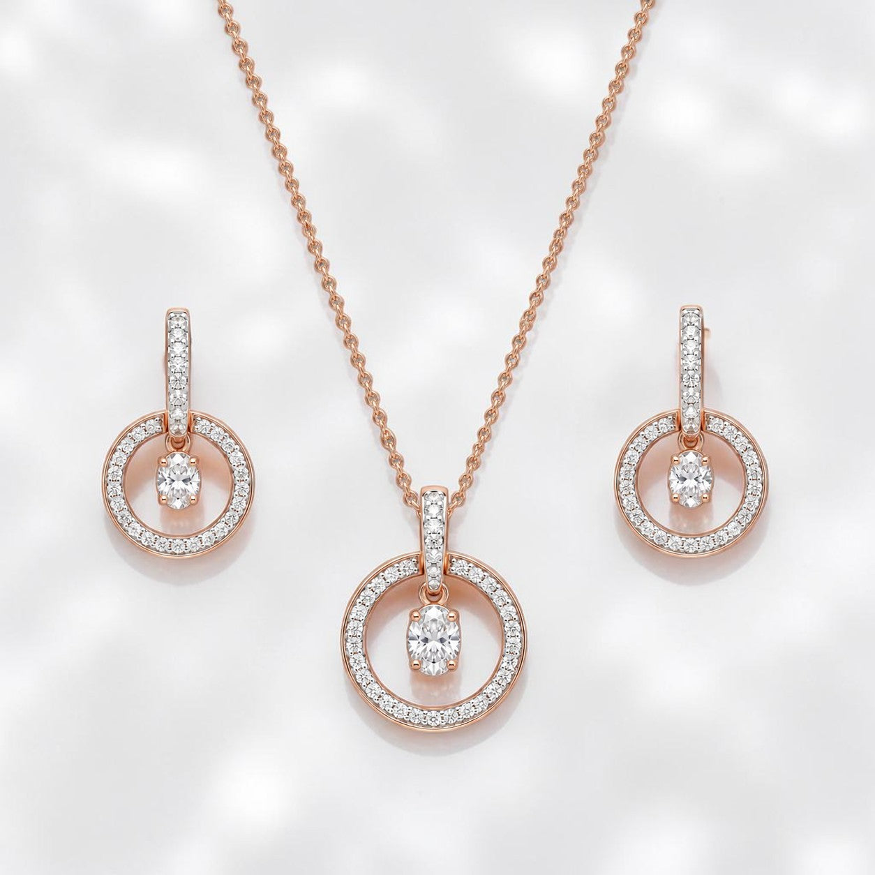 Elegant rose gold diamond jewelry set featuring a circular pendant necklace with matching dangling circle earrings on a white background.