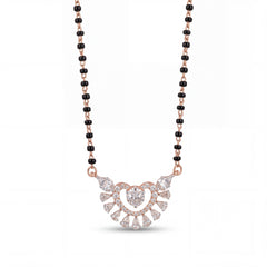 Elegant rose gold mangalsutra necklace featuring black beads and a sparkling heart-shaped floral diamond pendant with intricate detailing on a white background.
