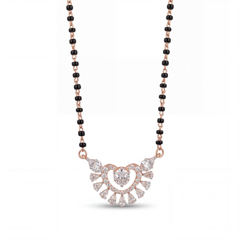 Elegant rose gold mangalsutra necklace featuring black beads and a sparkling heart-shaped floral diamond pendant with intricate detailing on a white background.