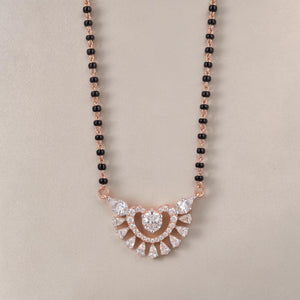 Elegant rose gold mangalsutra necklace featuring black beads and a sparkling heart-shaped floral diamond pendant with intricate detailing on a white background.