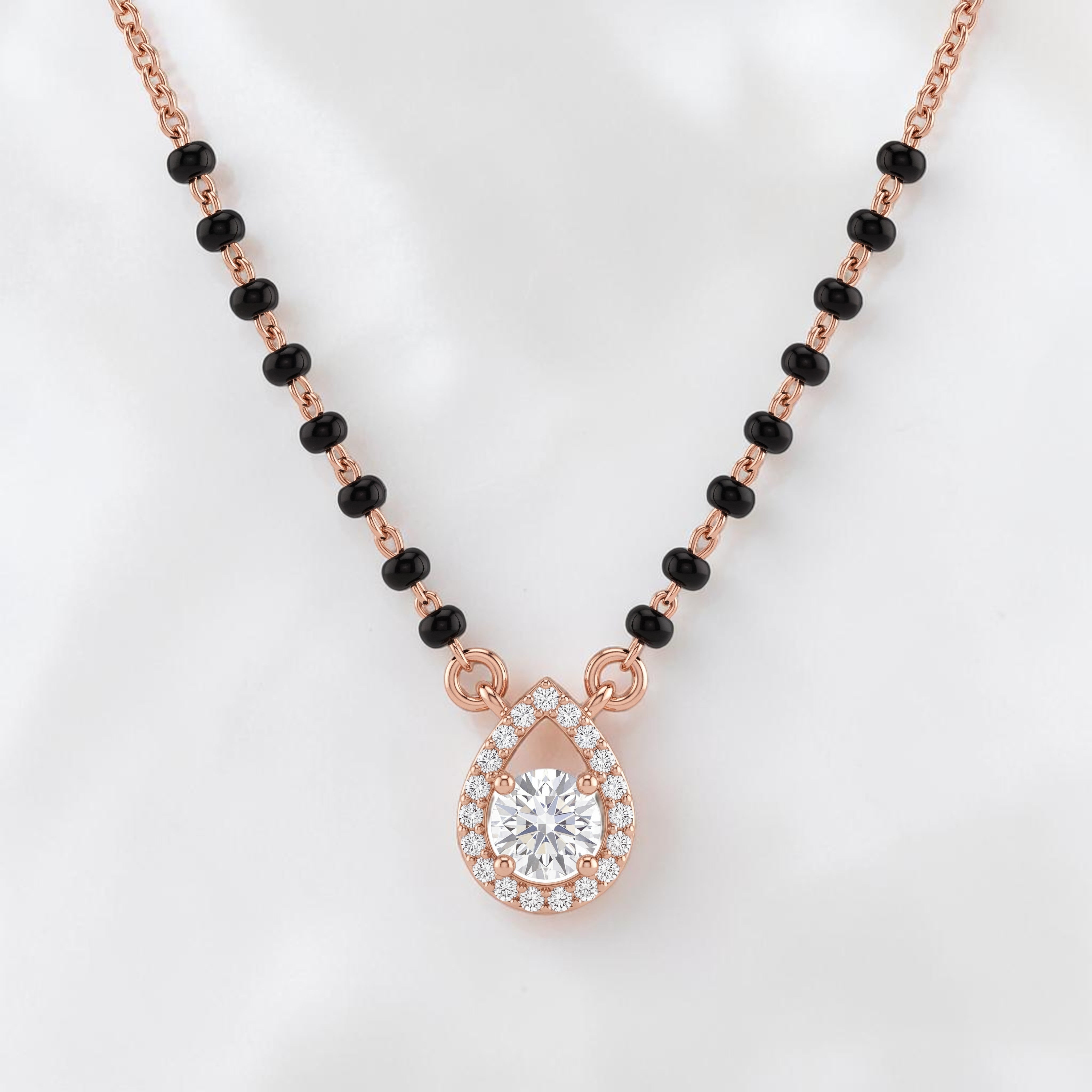Elegant rose gold mangalsutra necklace featuring black beads and a sparkling teardrop-shaped diamond pendant with halo detailing on a white background.