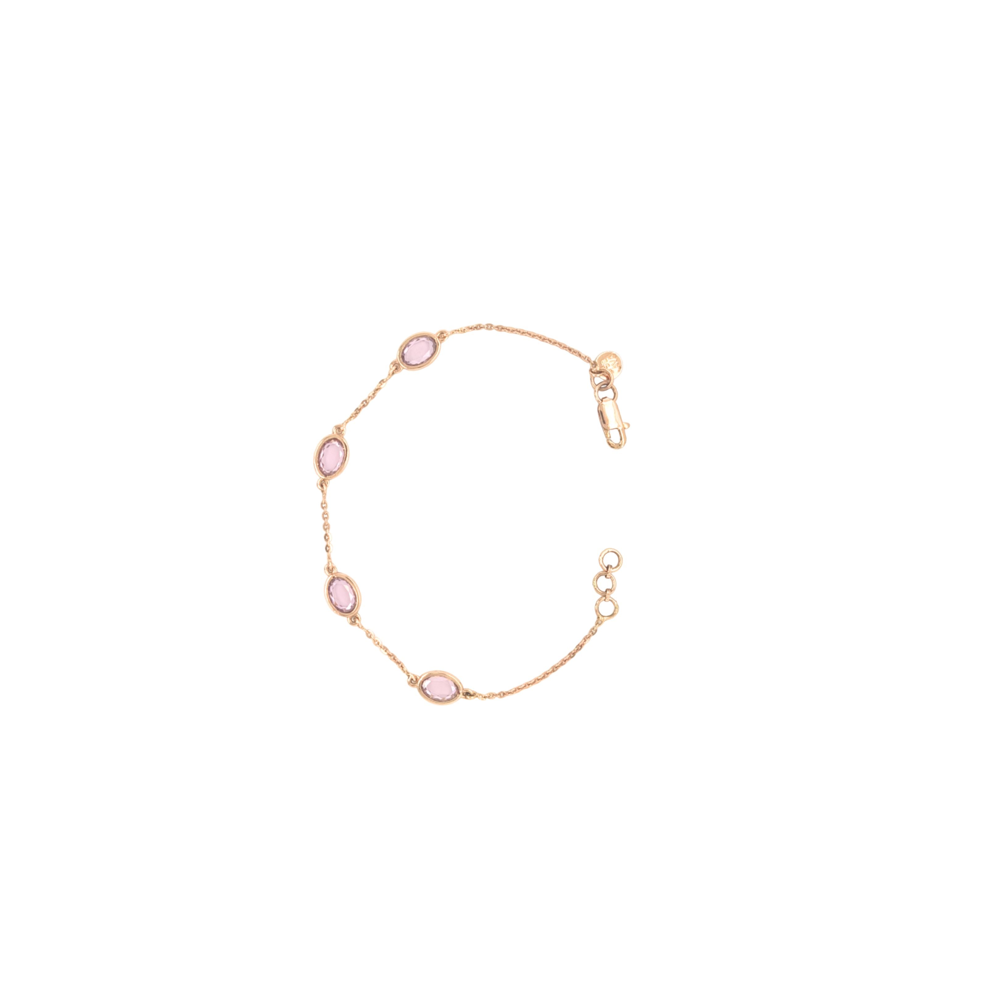 Elegant rose gold bracelet featuring oval pink gemstones spaced along a delicate chain with an adjustable clasp on a white background.