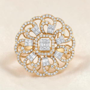 Elegant floral-inspired diamond ring featuring a square cluster center with baguette diamonds, surrounded by intricate looping patterns and round brilliant diamonds set in yellow gold.