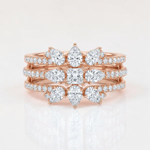 Rose gold multi-band ring featuring layered rows of pavé-set diamonds with pear-shaped and a central cushion-cut diamond arrangement, creating a crown-inspired, stacked statement design.