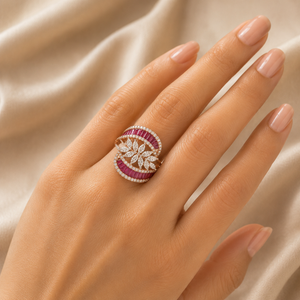 Luxurious gold statement ring featuring vibrant ruby accents in curved bands, with a delicate floral cluster of marquise-cut diamonds at the center.