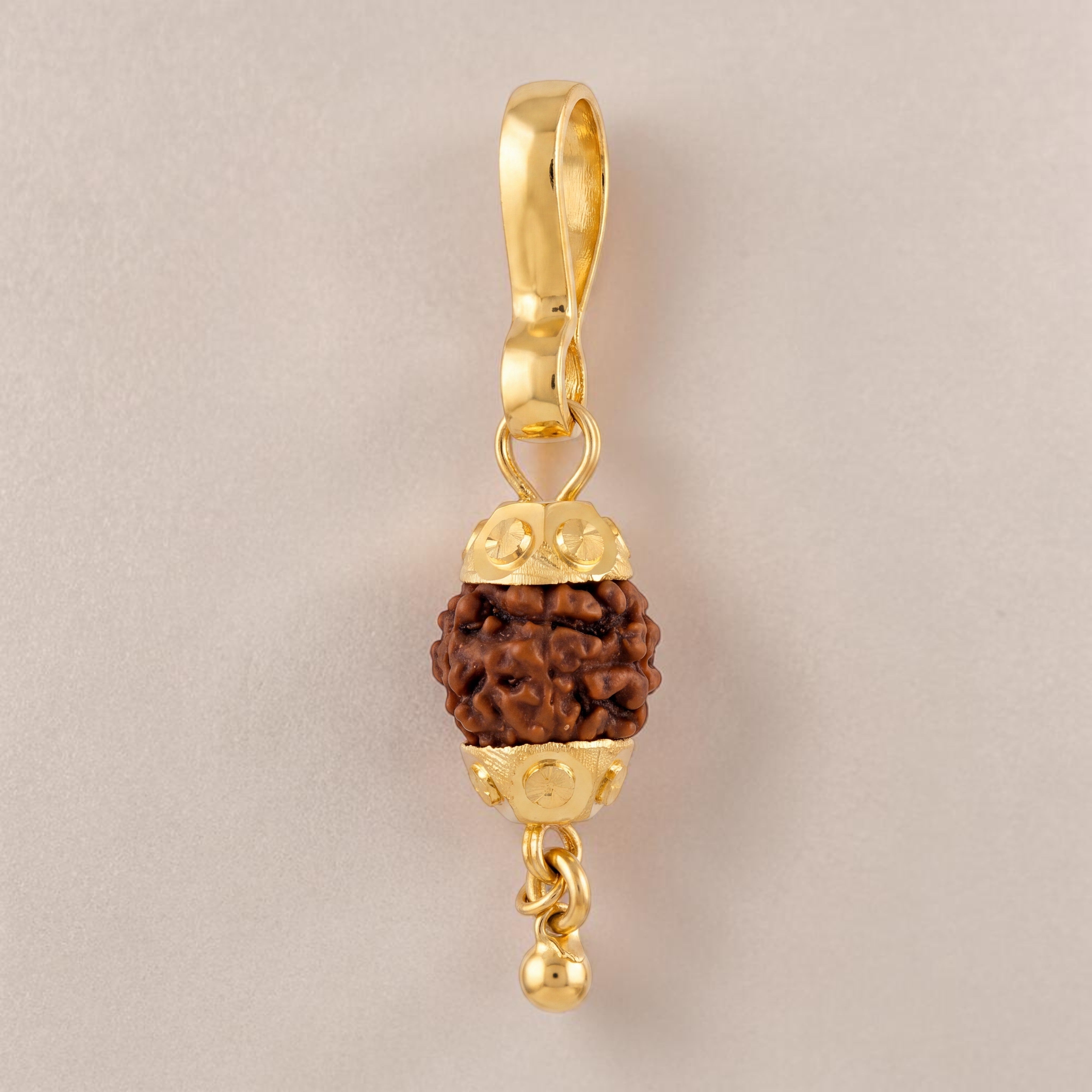 Yellow gold pendant featuring a natural Rudraksha bead encased with decorative gold caps and a small dangling gold bead, symbolizing spirituality and protection.