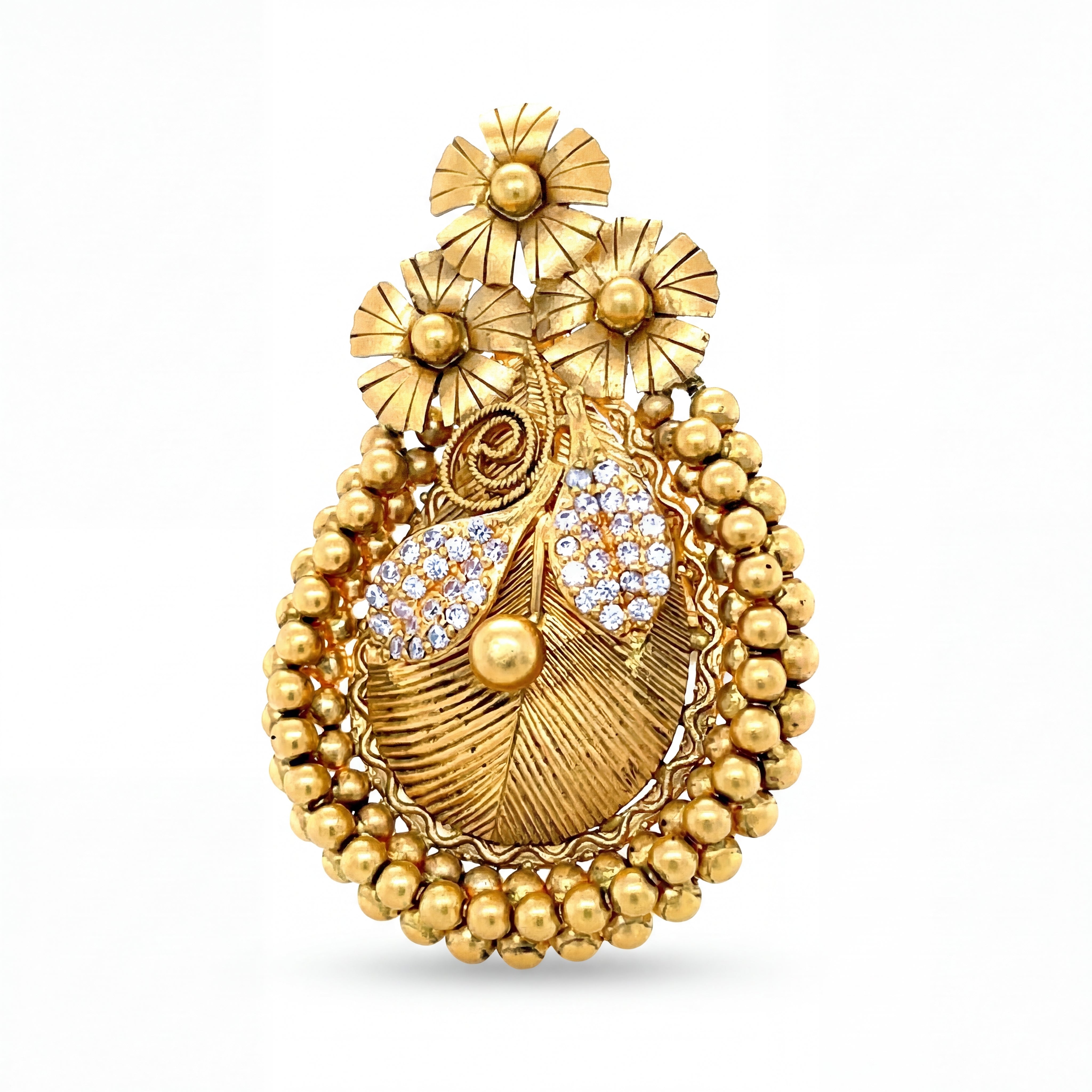 Intricately crafted yellow gold pendant featuring floral motifs, textured leaf detailing, diamond accents, and a decorative beaded border, offering a rich traditional design.